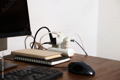 Billede på lærred Inflamed plug in power strip indoors on wooden table