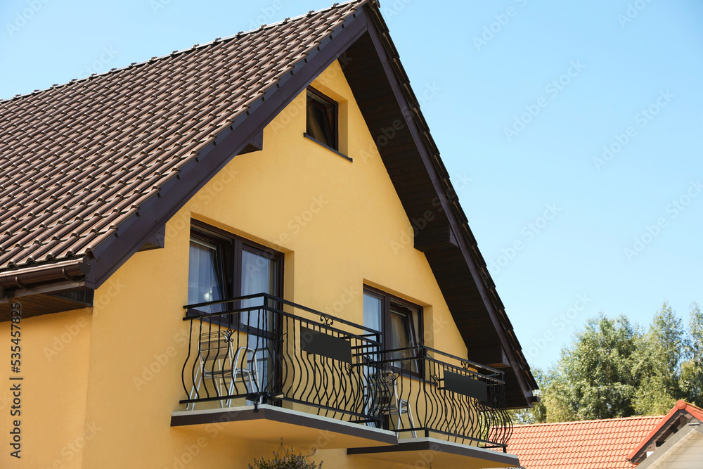 Exterior of beautiful house with balcony on sunny day