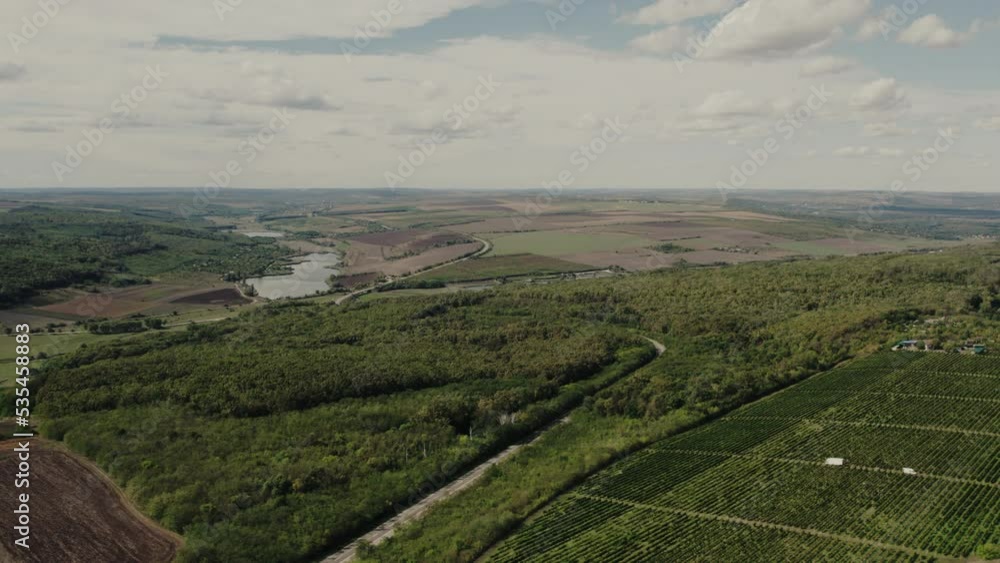 Cinematic aerial top view of the black soil autumn fields with small lake and cloudy sky. Drone shot of an autumn rural agriculture fields with harvest. Cinematic aerial top view of the black soil autumn fields with small lake and cloudy sky. Drone shot of an autumn rural agriculture fields with harvest.