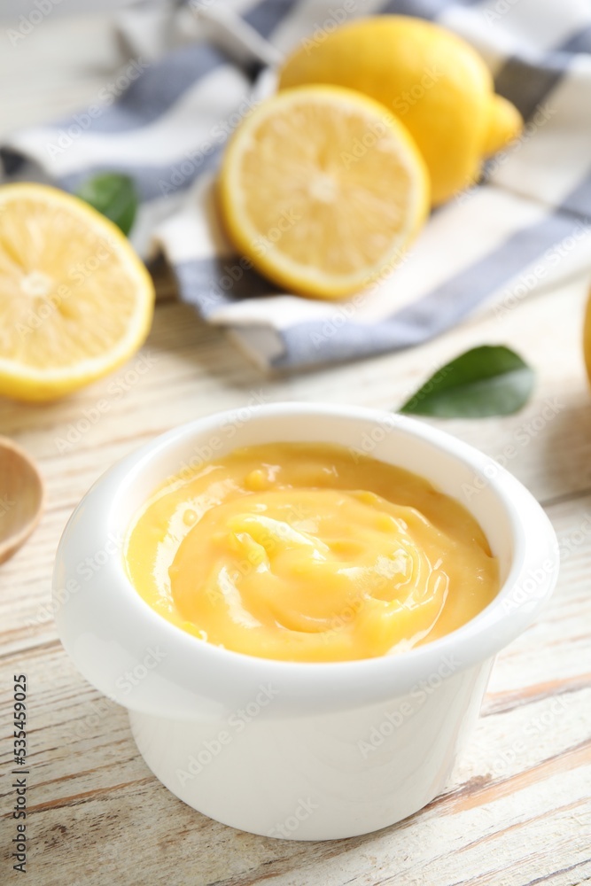 Delicious lemon curd in bowl on white wooden table, closeup Delicious lemon curd in bowl on white wooden table, closeup
