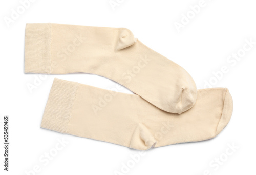 Pair of beige socks on white background, top view