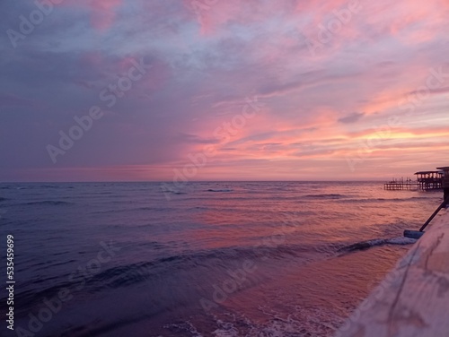 Gorgeous pink sunrise in Ada Bojana, Montenegro with a bright cloudy sky over the low sea tides photo
