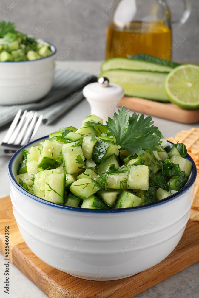 Bowl of delicious cucumber salad served on light table Bowl of delicious cucumber salad served on light table