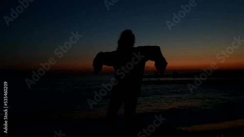 slow motion young woman dancing professionally towards sunset in the sky on the beach