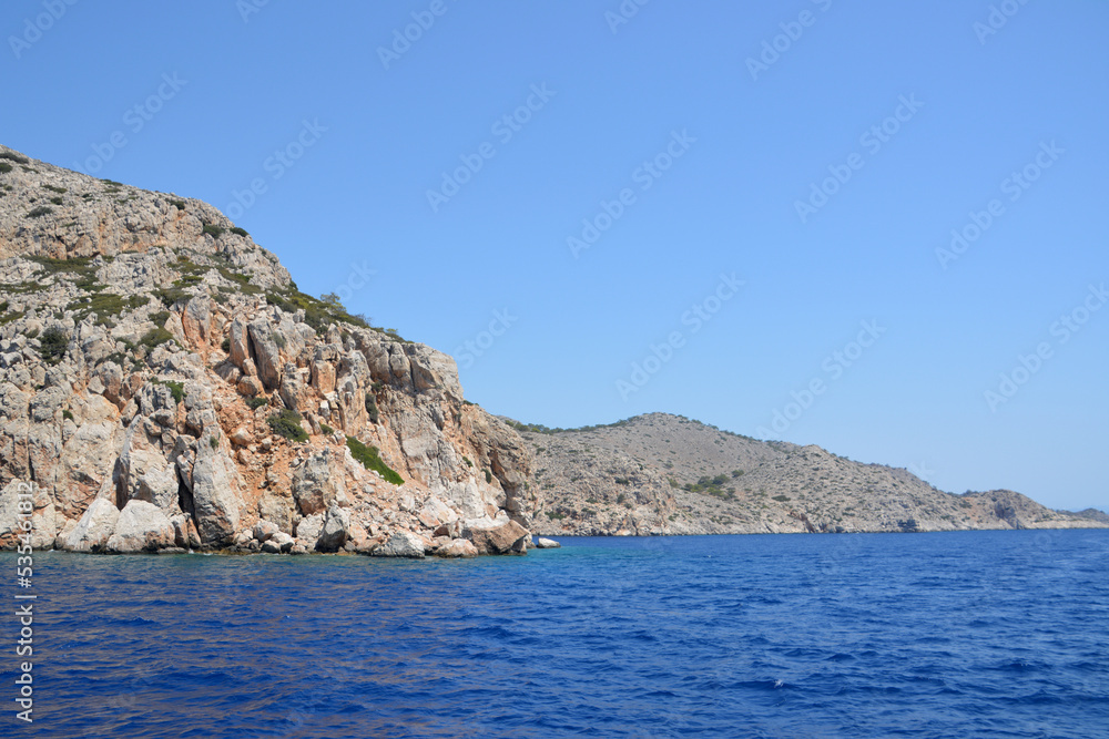 island with rocky hills, clear sky and blue sea, close-up