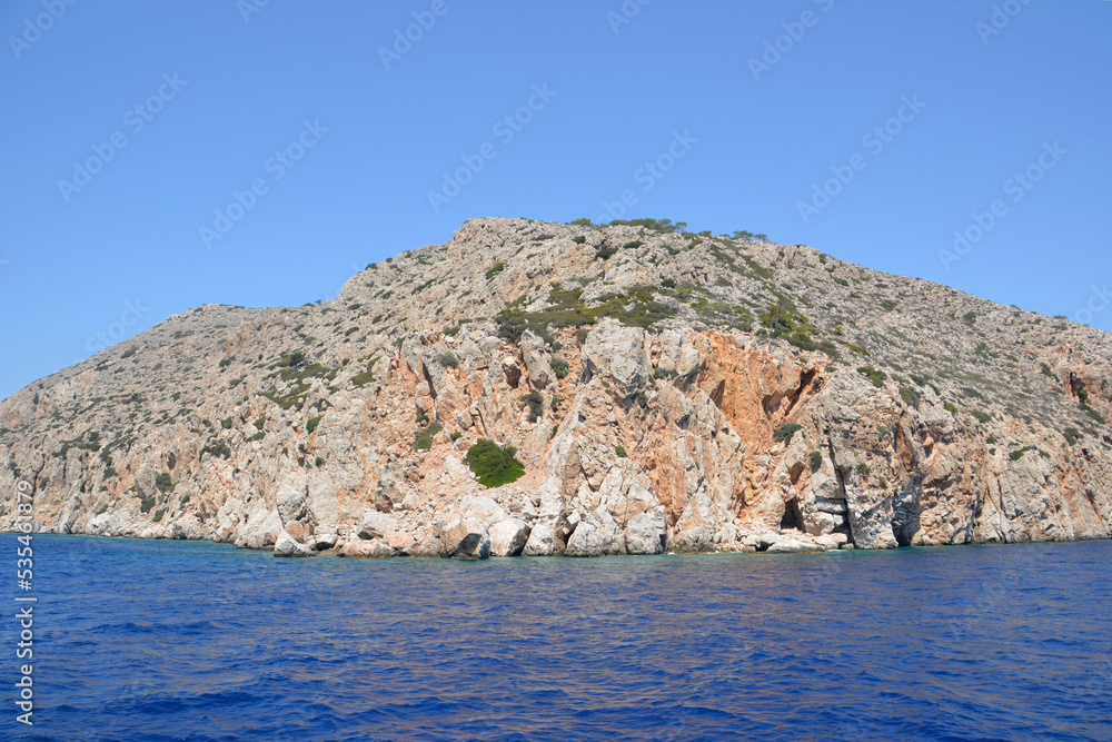 rocky island isolated with blue sky on horizon and blue sea