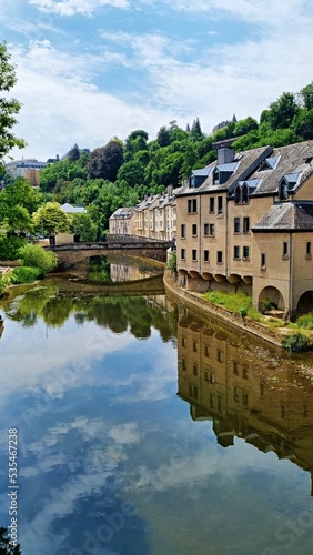 Vertical shot of buildings reflected in the river Alzette in Luxembourg photo