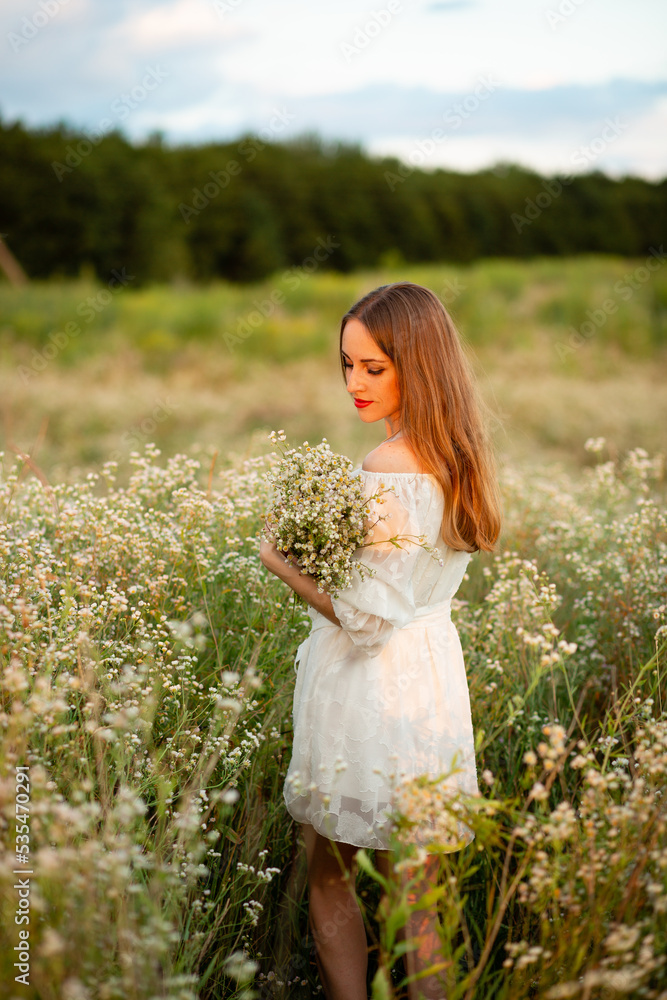 A girl in a wreath of daisies at sunset A girl in a wreath of daisies at sunset