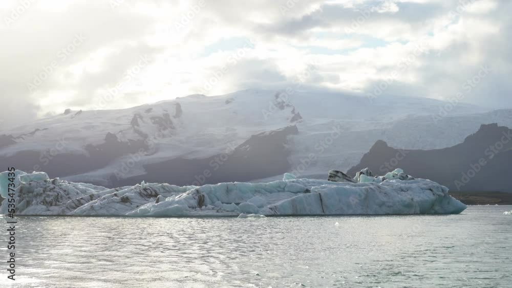 Icebergs float on Jokulsarlon glacier lagoon Iceland with sunshine and ripple ocean water, climate change global warming concept Icebergs float on Jokulsarlon glacier lagoon Iceland with sunshine and ripple ocean water, climate change global warming concept