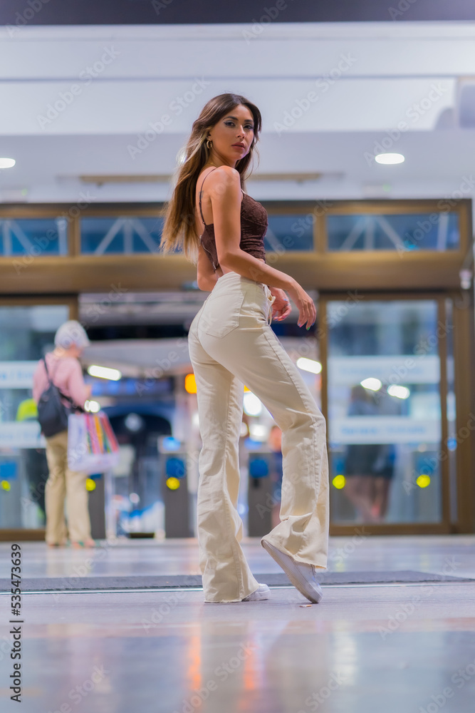 Fashion lifestyle, posed of a young brunette leaving the train station Fashion lifestyle, posed of a young brunette leaving the train station