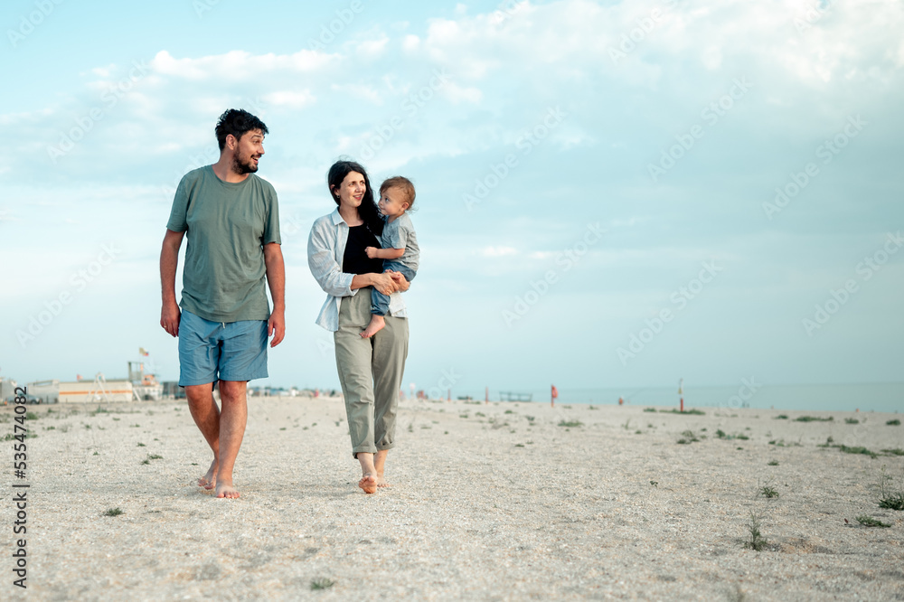 Happy family in the descent. Mom, dad and baby walk along the seashore. Happy family in the descent. Mom, dad and baby walk along the seashore.