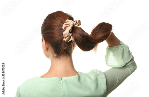 Woman with ponytail and silk scrunchy on white background photo