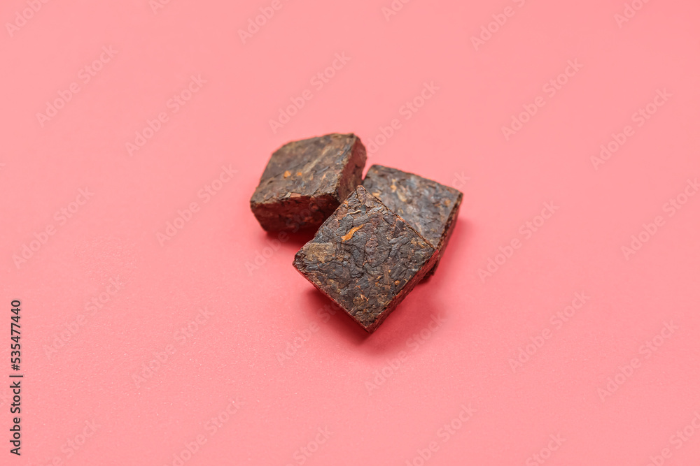 Dry pressed puer tea on pink background Dry pressed puer tea on pink background