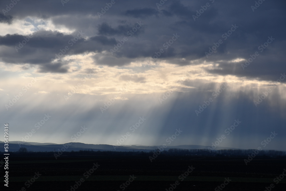 Sun rays from cloudy sky  over mountain