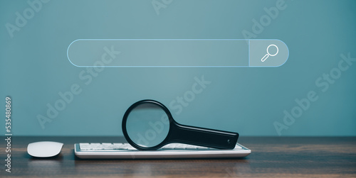 Photos Magnifying glass keyboard computer and  search bar or search box on virtual screen, browsing Internet global data Information