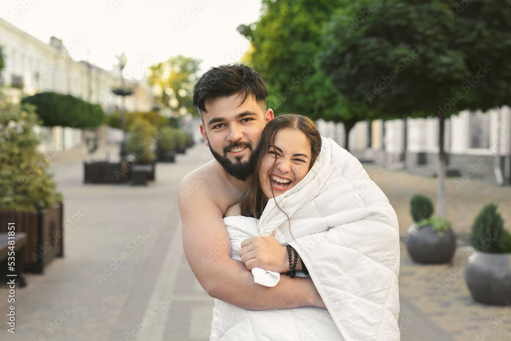 Fototapeta premium A couple in love, a man and a woman, hug and kiss on empty city streets at dawn in the morning.