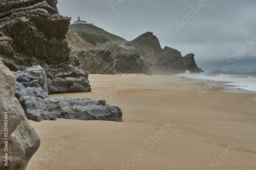 Formations on the sandy beach in Figueira da Foz, Portugal by water under stormy gray sky photo