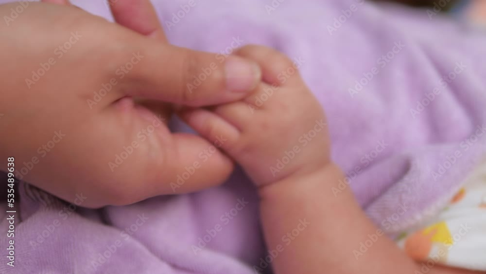 Hand of woman playing with hand of newborn baby, Select focus shallow depth of field Hand of woman playing with hand of newborn baby, Select focus shallow depth of field