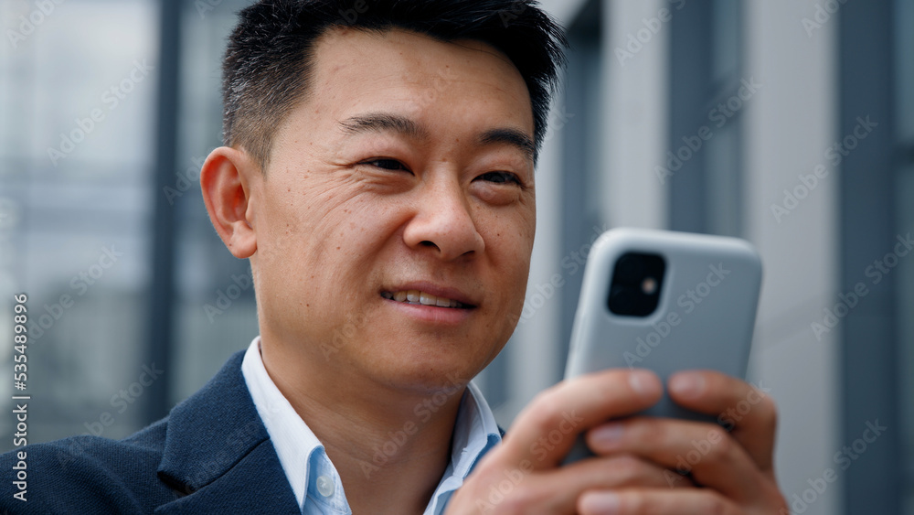 Close up male in city outdoors looking phone screen Asian 40s businessman entrepreneur employer man using mobile app map navigation in smartphone chatting browsing working distant virtual organizer Close up male in city outdoors looking phone screen Asian 40s businessman entrepreneur employer man using mobile app map navigation in smartphone chatting browsing working distant virtual organizer