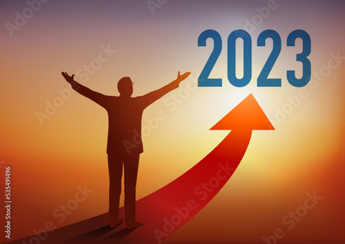 Carte de vœux 2023 montrant un homme d’affaires ouvrant les bras devant une flèche rouge en direction d’un horizon ensoleillé, symbole d’espoir et de réussite.