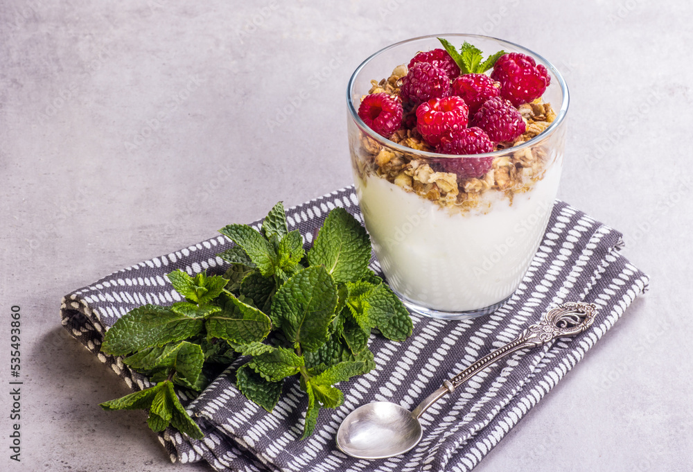 Glass of homemade yogurt with raspberries and granola