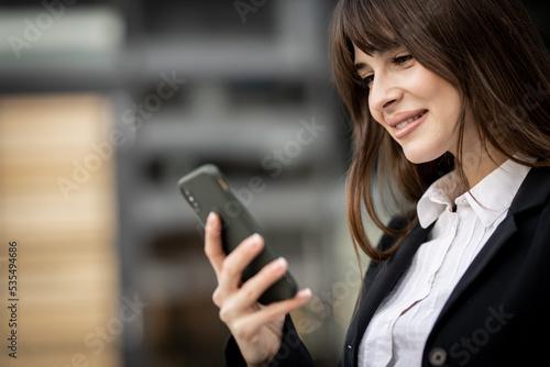 Business woman using mobile phone outdoors