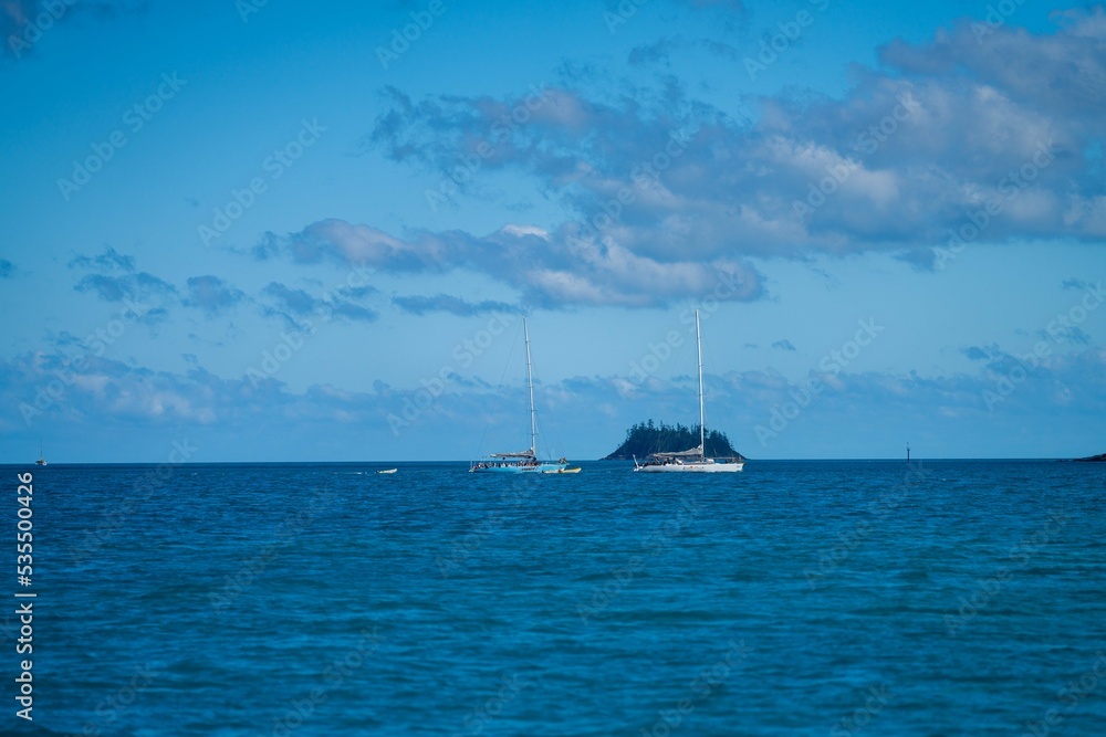 tourist boats and tour boats in the whitsundays queensland, australia. travellers on the great barrier reef, over coral and fish. tourism yachts of young people partying on the water tourist boats and tour boats in the whitsundays queensland, australia. travellers on the great barrier reef, over coral and fish. tourism yachts of young people partying on the water