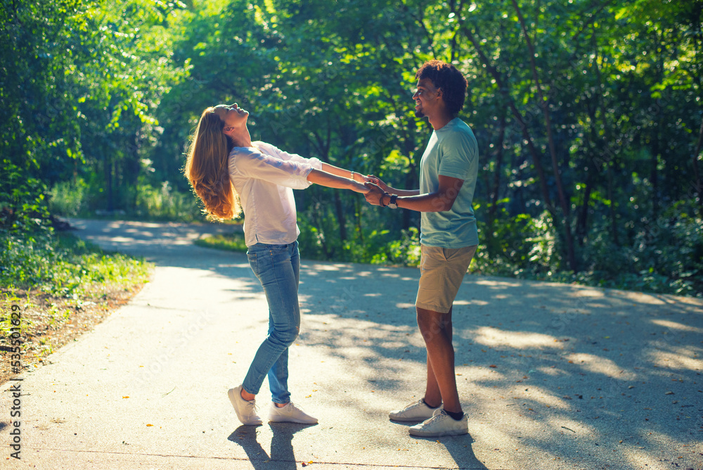 Young couple walking and holding hands in the nature on a sunny summer day Young couple walking and holding hands in the nature on a sunny summer day