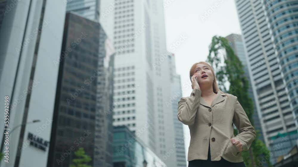 Happy young business woman walking in city street and speaking with smartphone Happy young business woman walking in city street and speaking with smartphone