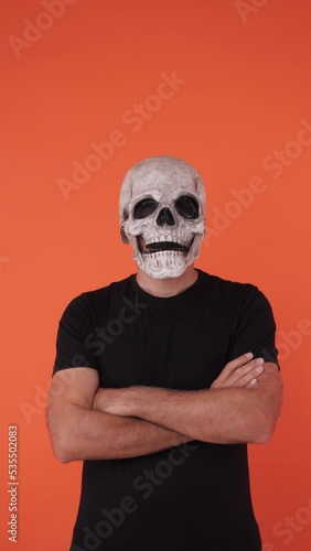 Person with skull mask celebrating Halloween, crossing arms. Celebration concept, All Souls' Day and All Saints' Day.