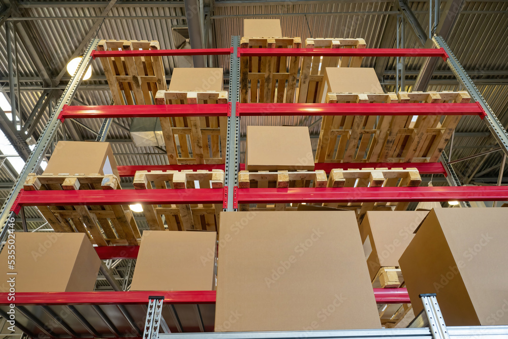 Storeroom interior. Cardboard boxes are stored on racks. Multitiered