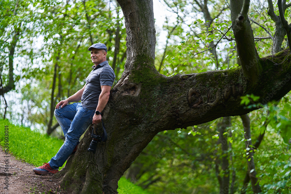 Travel photographer hiking in the forest mountains with his camera