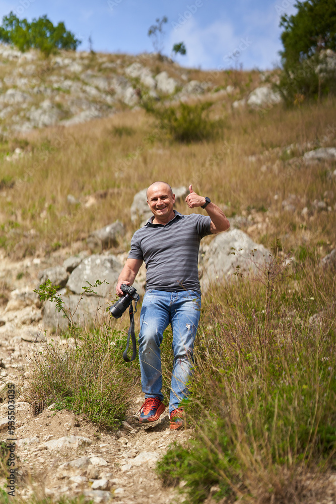 Travel photographer hiking in the forest mountains with his camera
