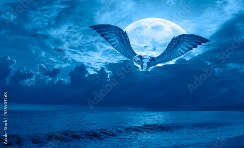 Night sky with blue full moon in the clouds with An african elephant flying over clouds  Elements of this image furnished by NASA 