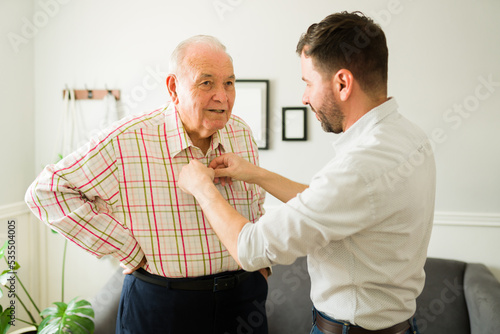 Foto Caucasian man giving a new shirt to his smiling old man