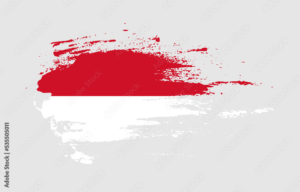 Grunge brush stroke flag of Monaco with painted brush splatter effect on solid background