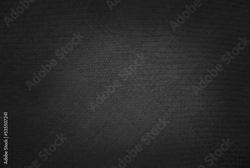 Old black reed weaving mat texture background, pattern of woven rattan mat in vintage style.