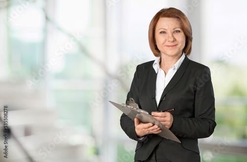 Happy business woman posing in modern office. © BillionPhotos.com