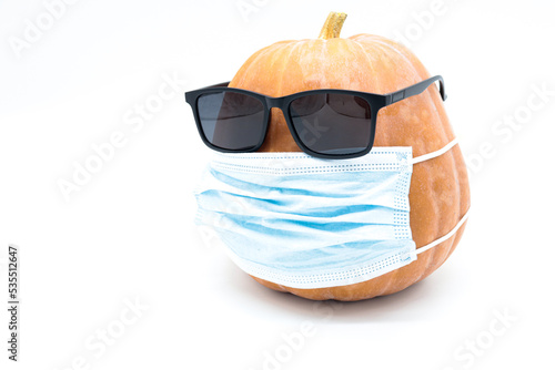 
pumpkin with face mask and sunglasses isolated on white background (hallowen covid 19 concept)