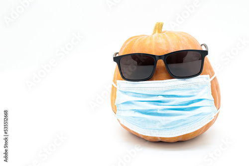 
pumpkin with face mask and sunglasses isolated on white background (hallowen covid 19 concept)