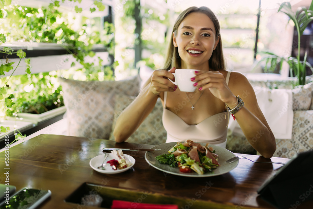 Portrait of a young smiling woman having a breakfast or lunch in a cafe Portrait of a young smiling woman having a breakfast or lunch in a cafe