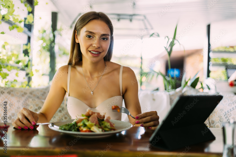 eating, technology, people and leisure concept - happy young woman with tablet p and food at restaurant eating, technology, people and leisure concept - happy young woman with tablet p and food at restaurant