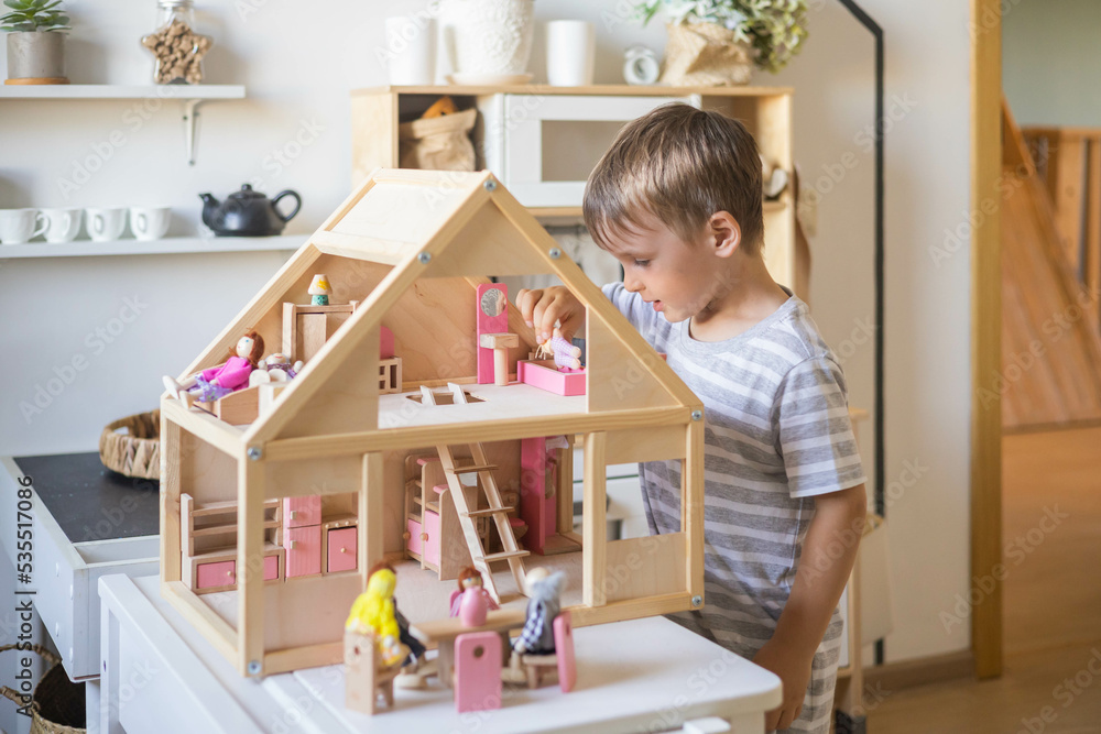 Cute male kid playing toy doll house with interior furniture Montessori  wooden eco friendly material Stock Photo | Adobe Stock