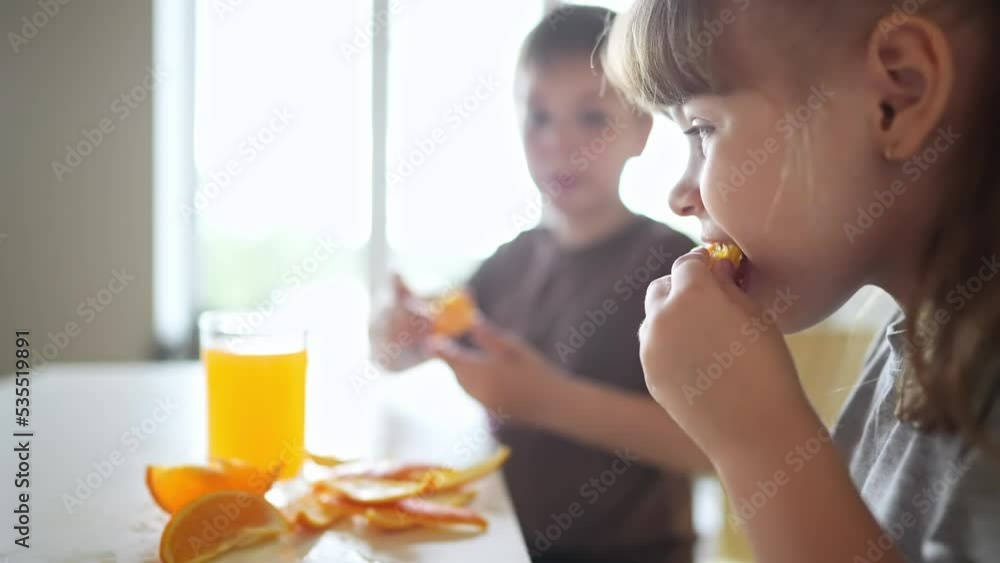 children eat oranges. happy family a kid dream concept. drinking fresh juices. morning breakfast brother and sister eat oranges in the kitchen fun. fruits orange juice healthy eating children eat oranges. happy family a kid dream concept. drinking fresh juices. morning breakfast brother and sister eat oranges in the kitchen fun. fruits orange juice healthy eating