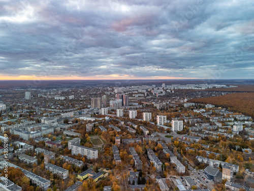 Aerial autumn city sunset view with epic cloudscape. Pavlovo Pole residential district buildings in evening light. Kharkiv, Ukraine
