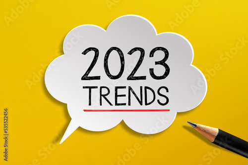 2023 Trends written on speech bubble with pencil on yellow background  photo