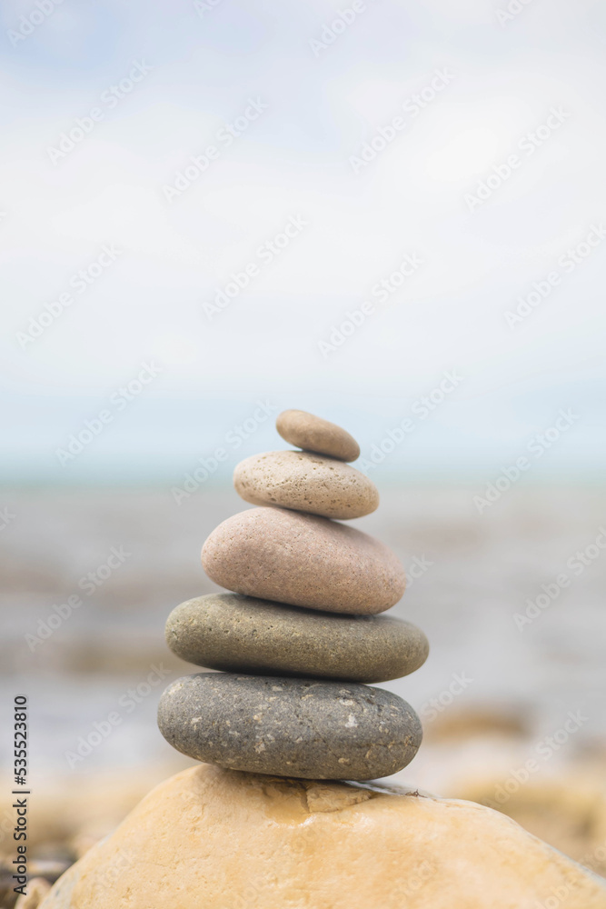 Pebble tower on sunny beach sea wave splashing water balance pyramid harmony peace of mind Pebble tower on sunny beach sea wave splashing water balance pyramid harmony peace of mind