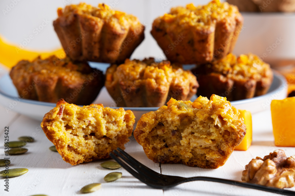 Highlighted focus on a broken pumpkin muffin next to the fork. Healthy dietary food, healthy breakfast or snack. Highlighted focus on a broken pumpkin muffin next to the fork. Healthy dietary food, healthy breakfast or snack.