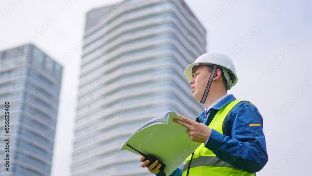 young man technician working with blueprint construction site near modern building young man technician working with blueprint construction site near modern building