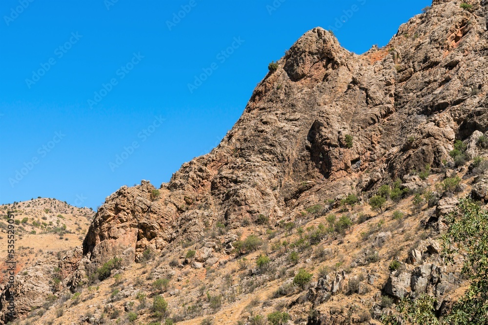 A rocky ledge with sharp edges on a mountain slope in the mountains of Armenia.